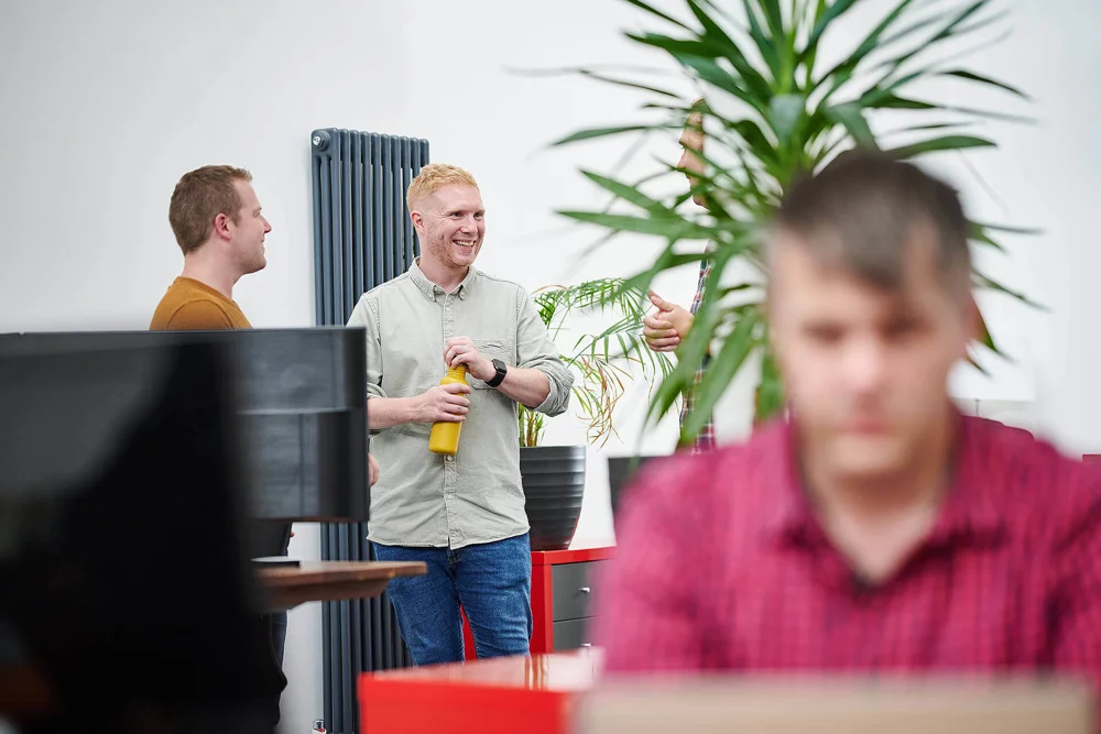 Kevin Triggle and Stuart Hobbs stood talking with person blurred in the foreground