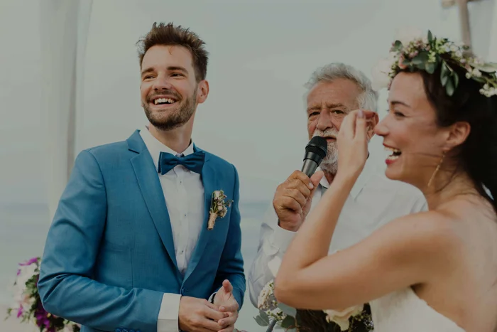 Man and woman getting married with a man holding a mic in the background