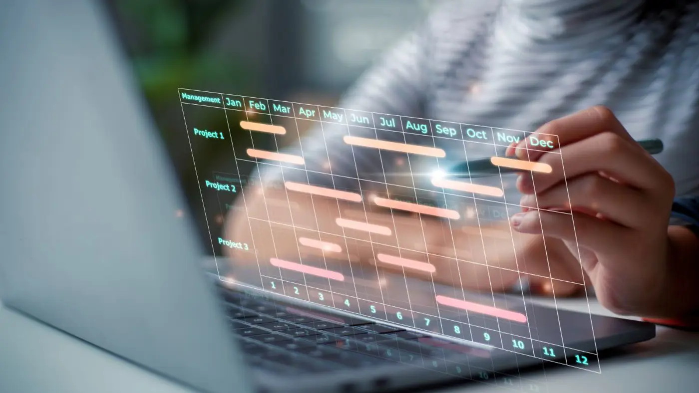 Person using a laptop with a virtual Gantt chart interface showing project timelines and milestones for project management within digital transformation programme.