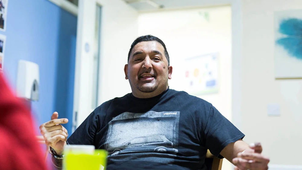 Man sat at table at Disabilities Trust Osman House