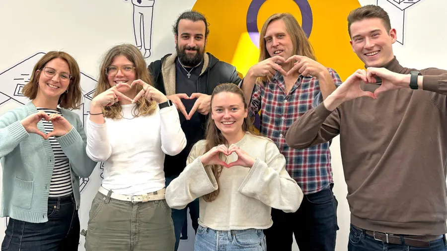 Digital Wonderlab team making heart symbol with hands in office