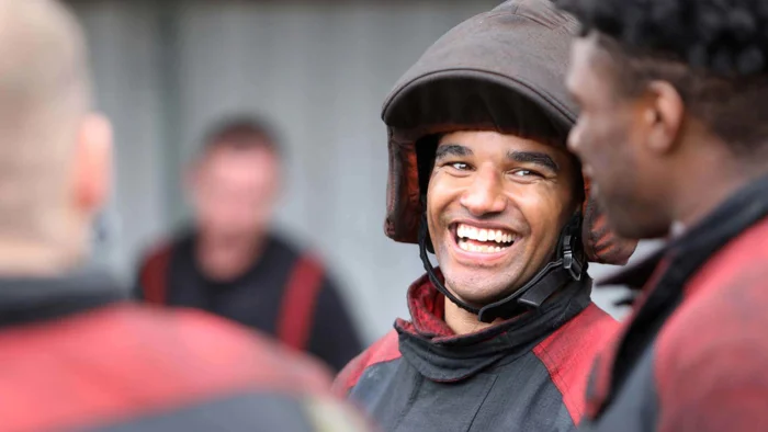 Firefighters in group, one looking forward and smiling